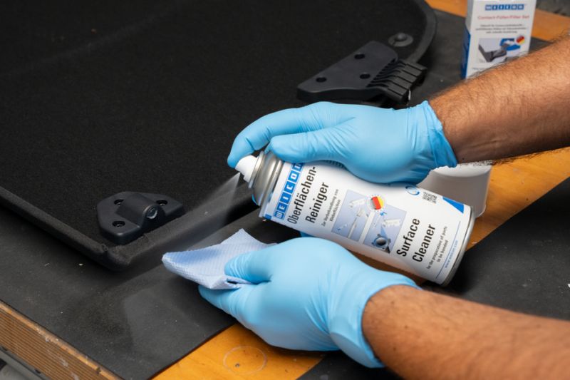 surface cleaner, spray can, gloved hands, workbench, cleaning cloth